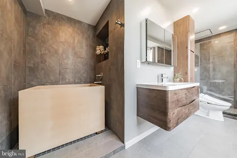 a bathroom with a tub sink and mirror
