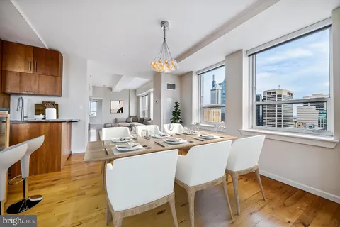 a dining room with furniture a chandelier and wooden floor