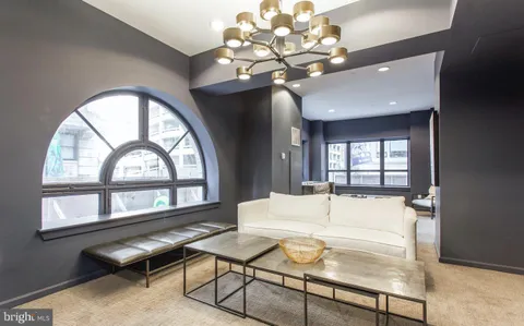 a living room with furniture a chandelier and a large window