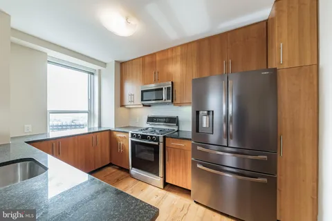 a kitchen with stainless steel appliances granite countertop a refrigerator stove and sink