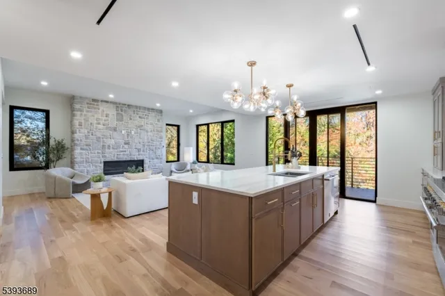 a large kitchen with stainless steel appliances granite countertop a stove and a wooden floors