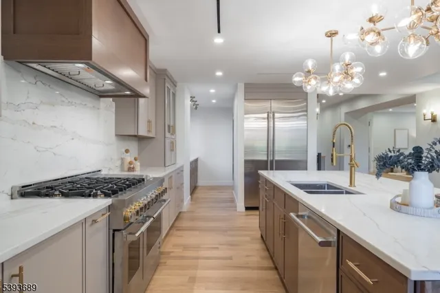 a kitchen with kitchen island stainless steel appliances a sink stove and cabinets