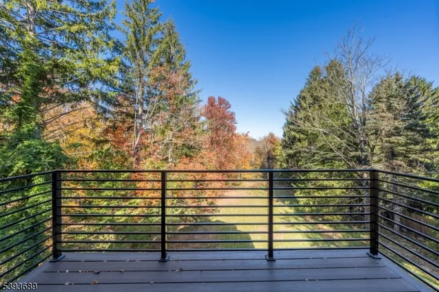 a view of a balcony with wooden floor and trees