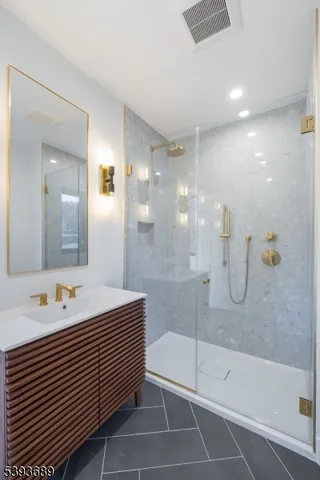 a bathroom with a shower sink and mirror