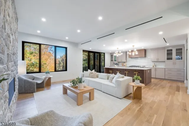 a living room with furniture kitchen view and a large window