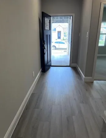 an empty room with wooden floor and a window