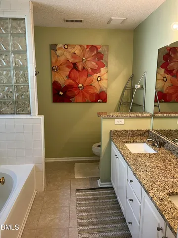 a bathroom with a granite countertop sink and a bathtub