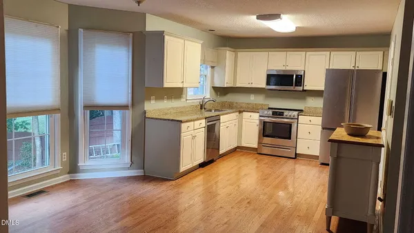 a kitchen with stainless steel appliances granite countertop a stove a sink and a refrigerator