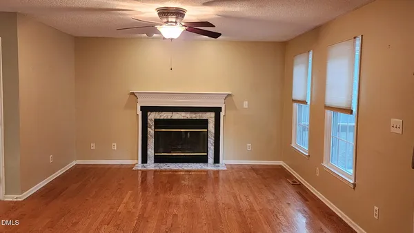 a view of an empty room with a fireplace and a window