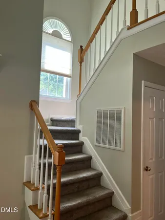 a view of staircase with lots of frames on wall and a window