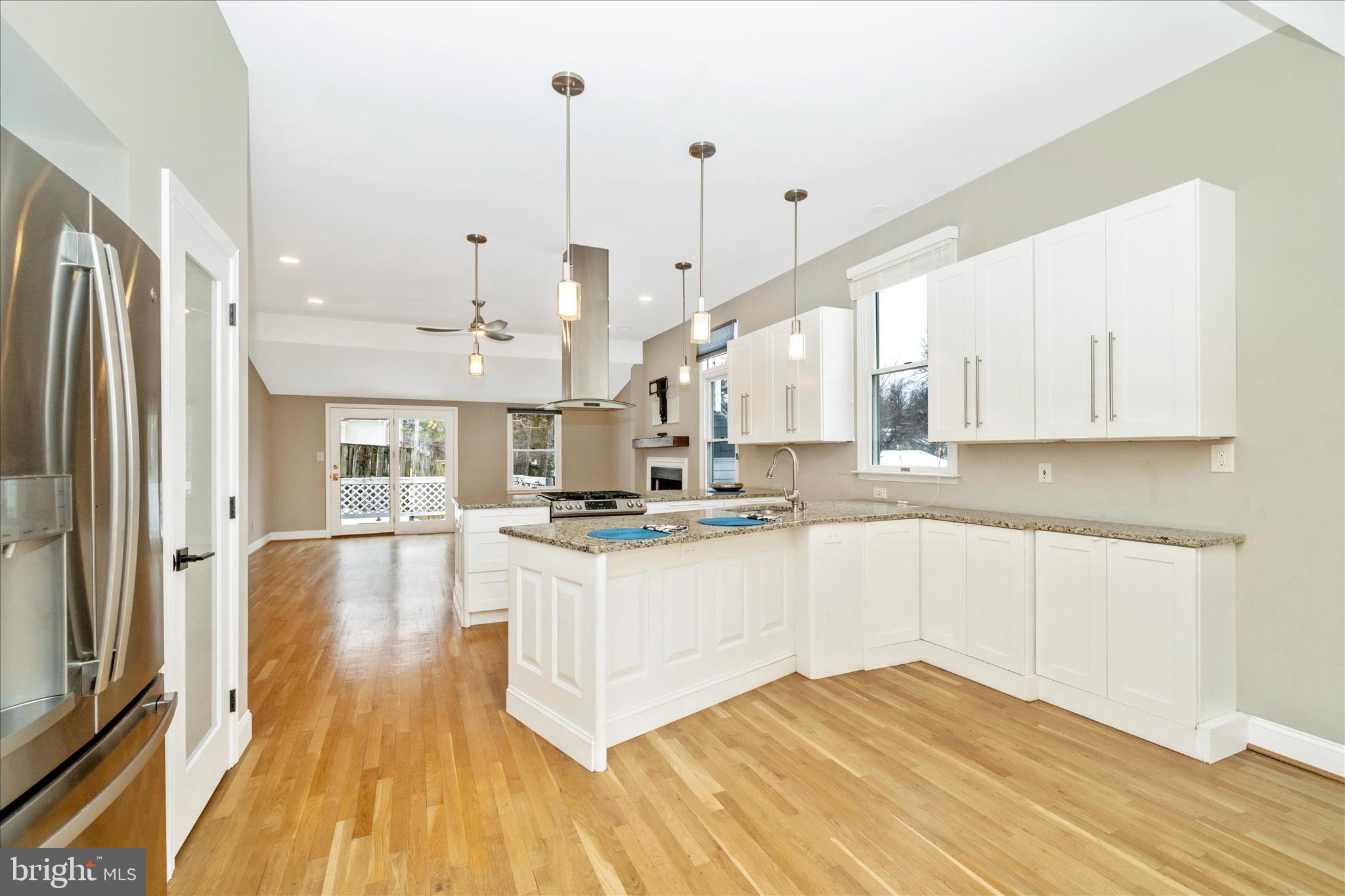 3313 Moline Road Silver Spring, MD 20902 - Photo 6 of 66 a large kitchen with kitchen island a stove a sink a refrigerator and white cabinets with wooden floor