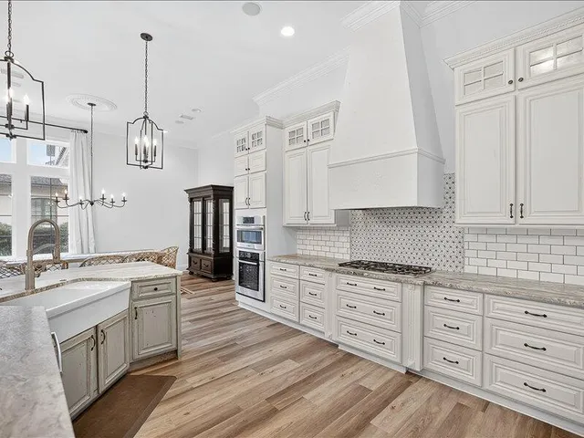 a kitchen with cabinets and chandelier