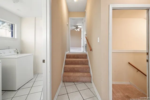 a view of a hallway to rooms and stairs