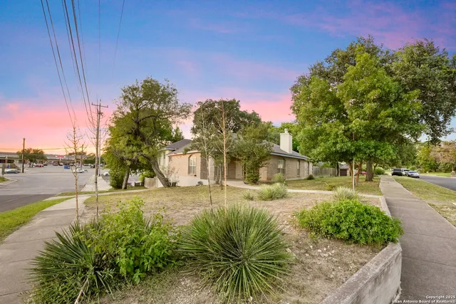 a front view of a house with a yard and trees