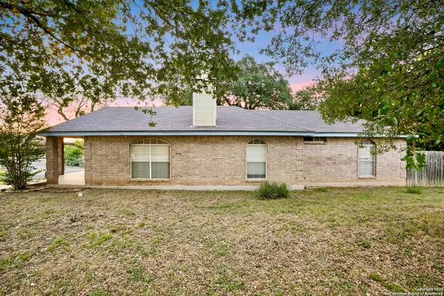 a view of a yard in front of a house with large tree