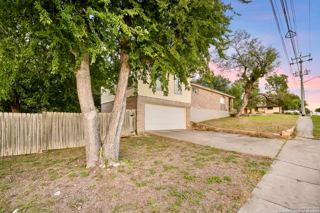 a view of a house with a tree in the yard