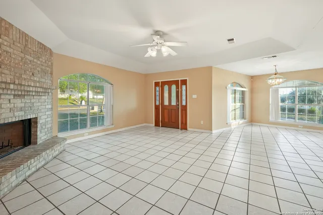 a view of an empty room with a fireplace and a window
