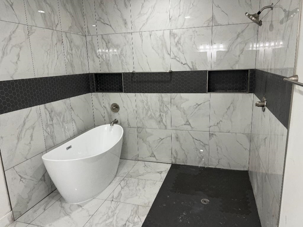 56 South Sanga Road Memphis, TN 38018 - Photo 2 of 23 Full bath with a marble finish shower, a freestanding tub, marble finish flooring, and tile walls