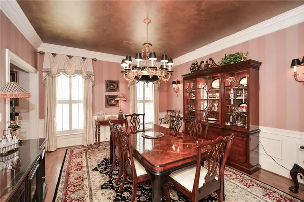 a living room with furniture large windows and wooden floor