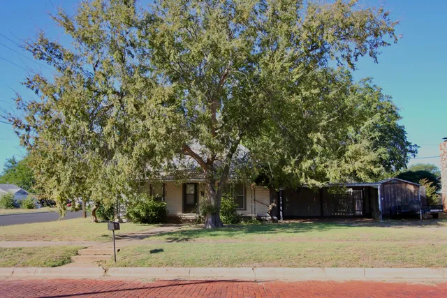 a front view of a house with a tree