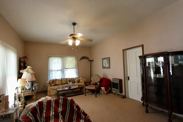a living room with furniture a window and a flat screen tv