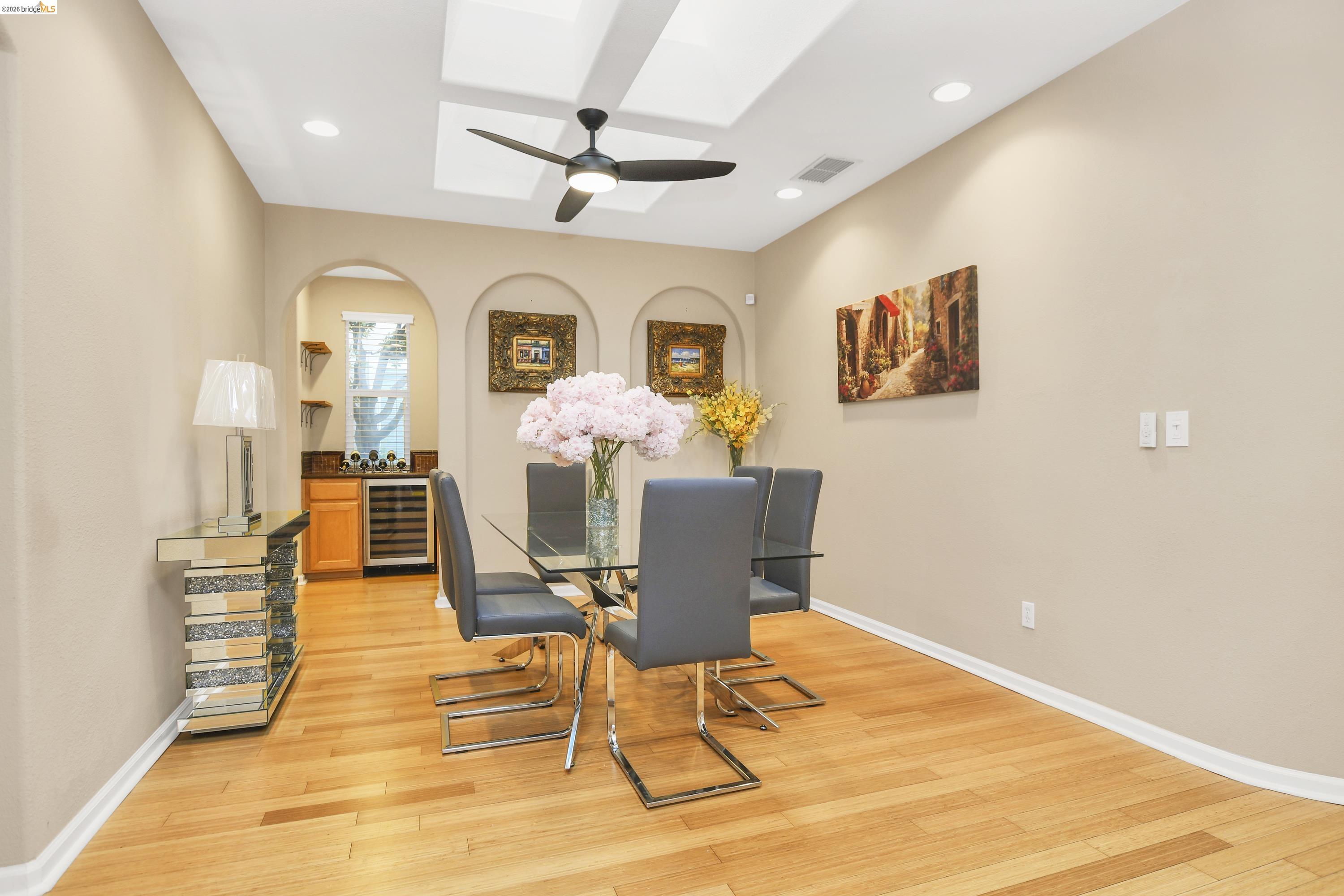342 Desert Forest Court Rio Vista, CA 94571 - Photo 19 of 40 Dining space with a skylight, light wood-type flooring, beverage cooler, arched walkways, and a ceiling fan