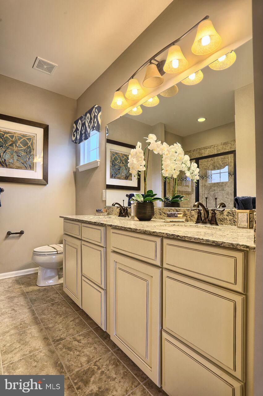 3142 Sunny Ridge Drive Odenton, MD 21113 - Photo 12 of 30 a view of a bathroom with a sink and mirror with toilet
