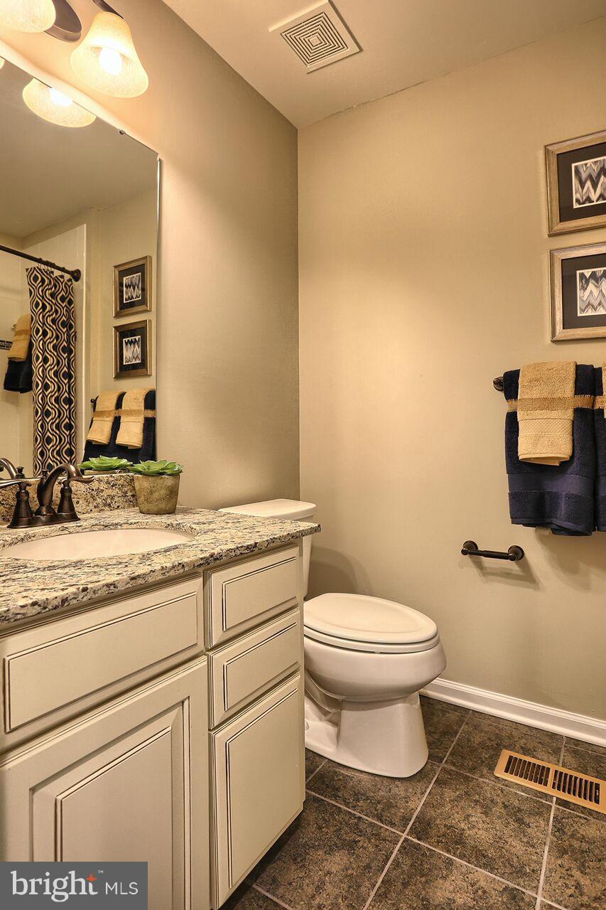 3142 Sunny Ridge Drive Odenton, MD 21113 - Photo 5 of 30 a bathroom with a granite countertop toilet sink and mirror