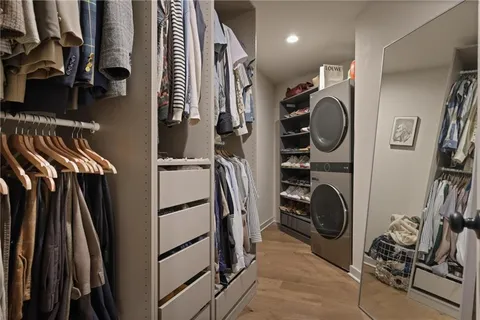 a view of walk in closet with clothes and shoes