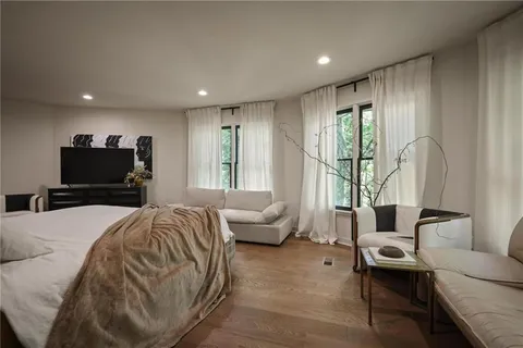a spacious bedroom with a bed and glass windows