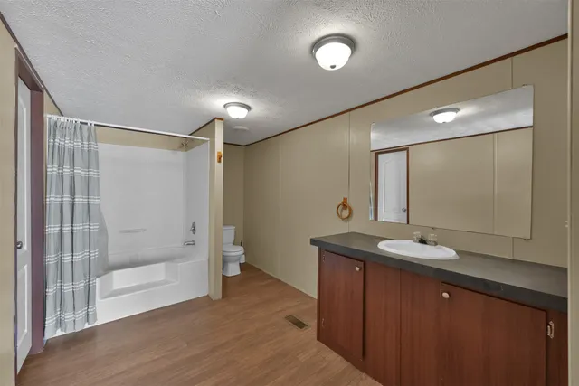 a bathroom with a granite countertop sink mirror and shower