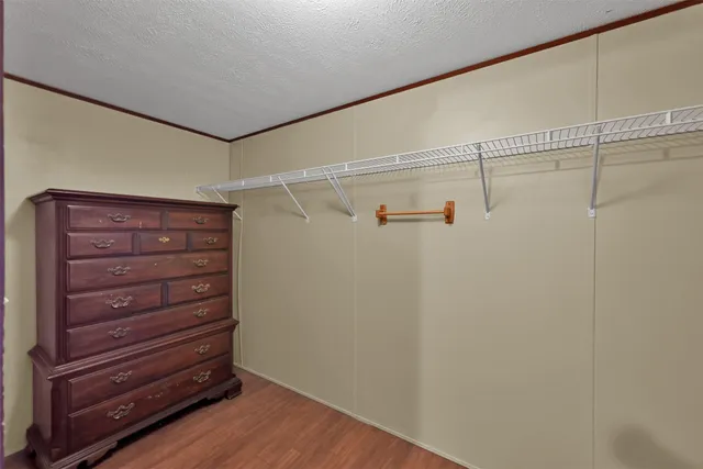 a view of walk in closet with empty racks