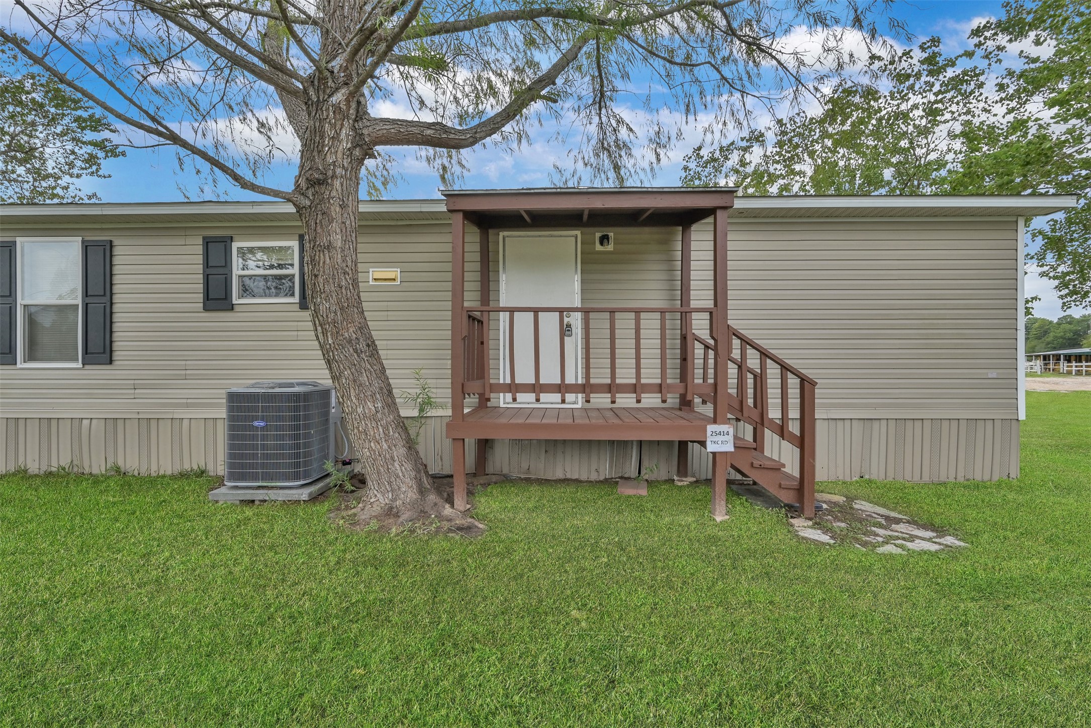 25414 T K C Road Tomball, TX 77375 - Photo 2 of 17 a view of a house with a small yard and a large tree