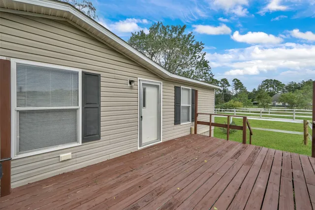 a view of house with deck and outdoor space