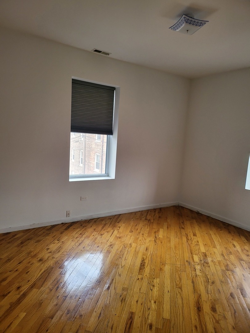 820 East 44th Street, Unit 2 Chicago, IL 60653 - Photo 9 of 12 an empty room with wooden floor and windows