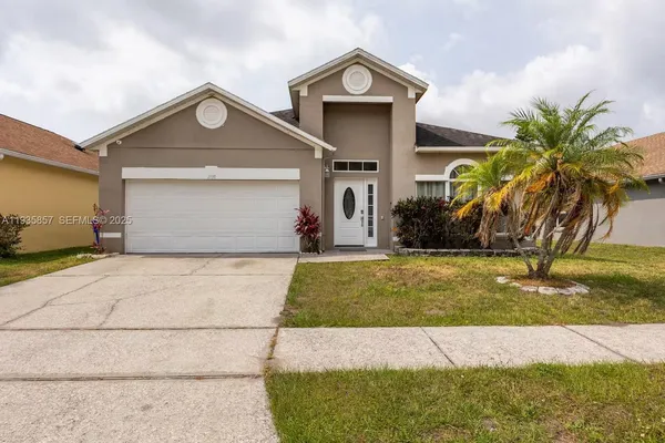 a front view of a house with a yard and garage