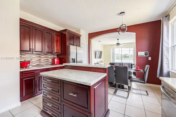 a view of kitchen with stainless steel appliances granite countertop dining table and chairs