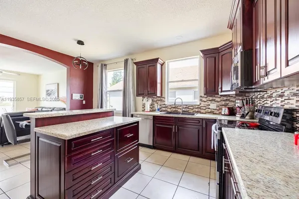 a kitchen with kitchen island granite countertop a sink counter top space and appliances