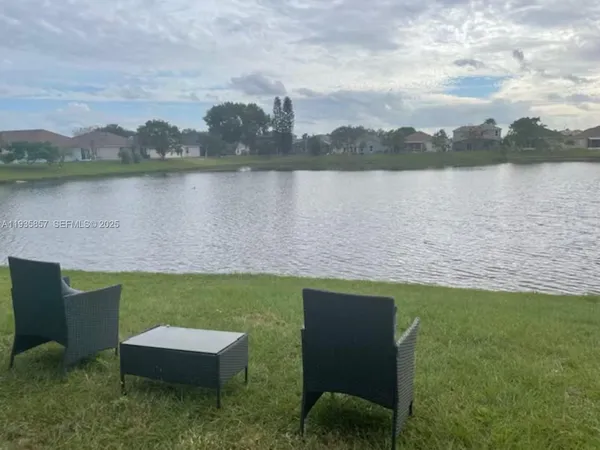 a view of a lake with couches in the back yard