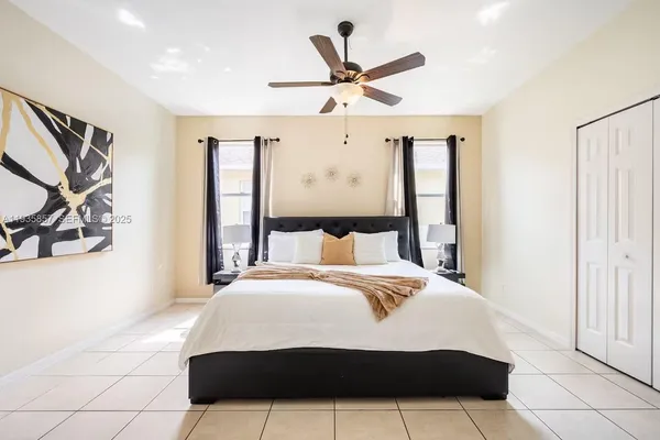 a bedroom with a large bed and a ceiling fan