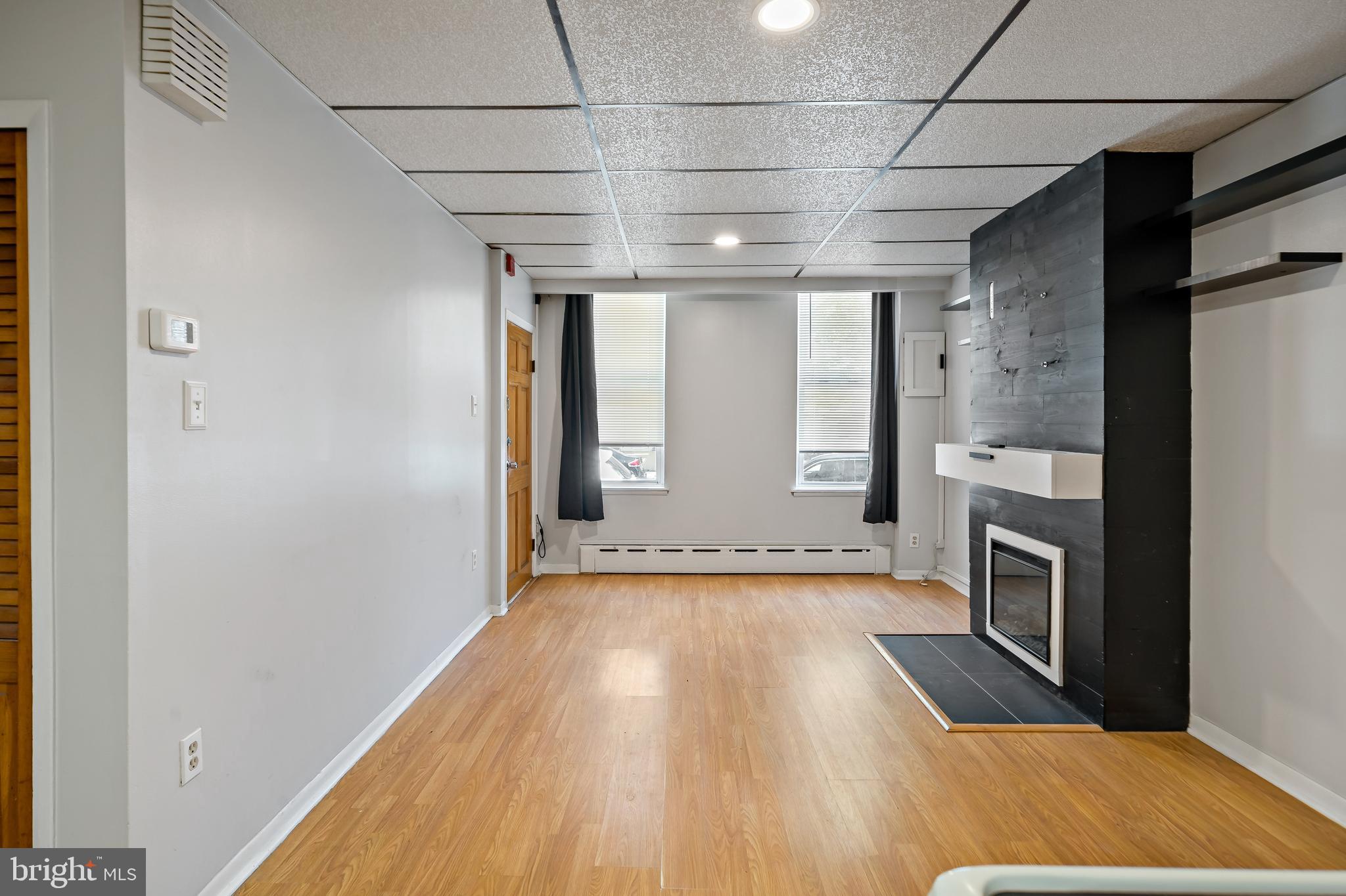 1304 Jackson Street, Unit 1 Philadelphia, PA 19148 - Photo 6 of 16 a view of an empty room with a fireplace and a window