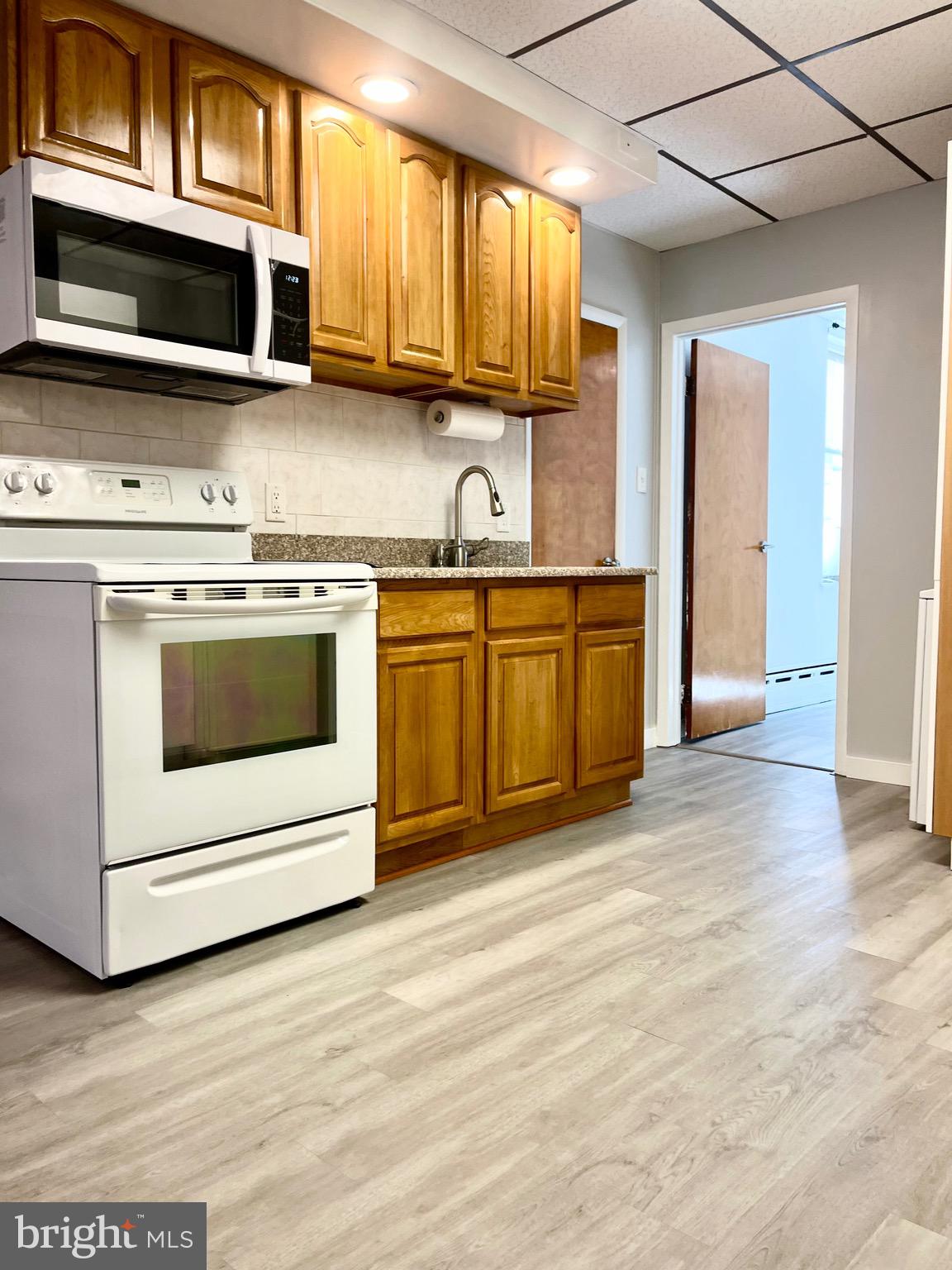 1304 Jackson Street, Unit 1 Philadelphia, PA 19148 - Photo 10 of 16 a kitchen with stainless steel appliances granite countertop a stove microwave and sink