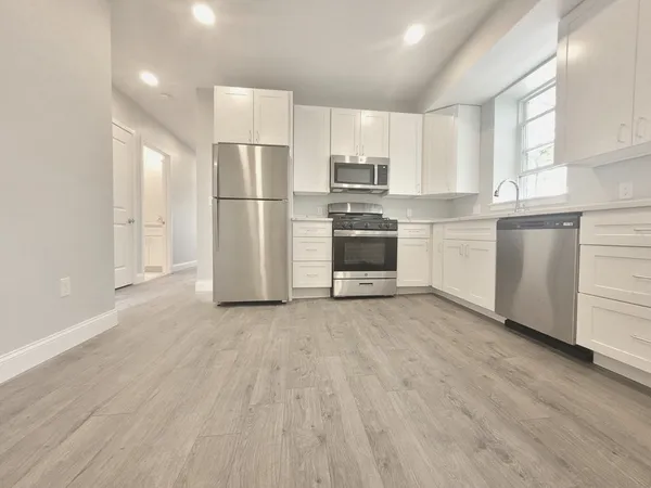 a kitchen with stainless steel appliances a refrigerator sink and microwave