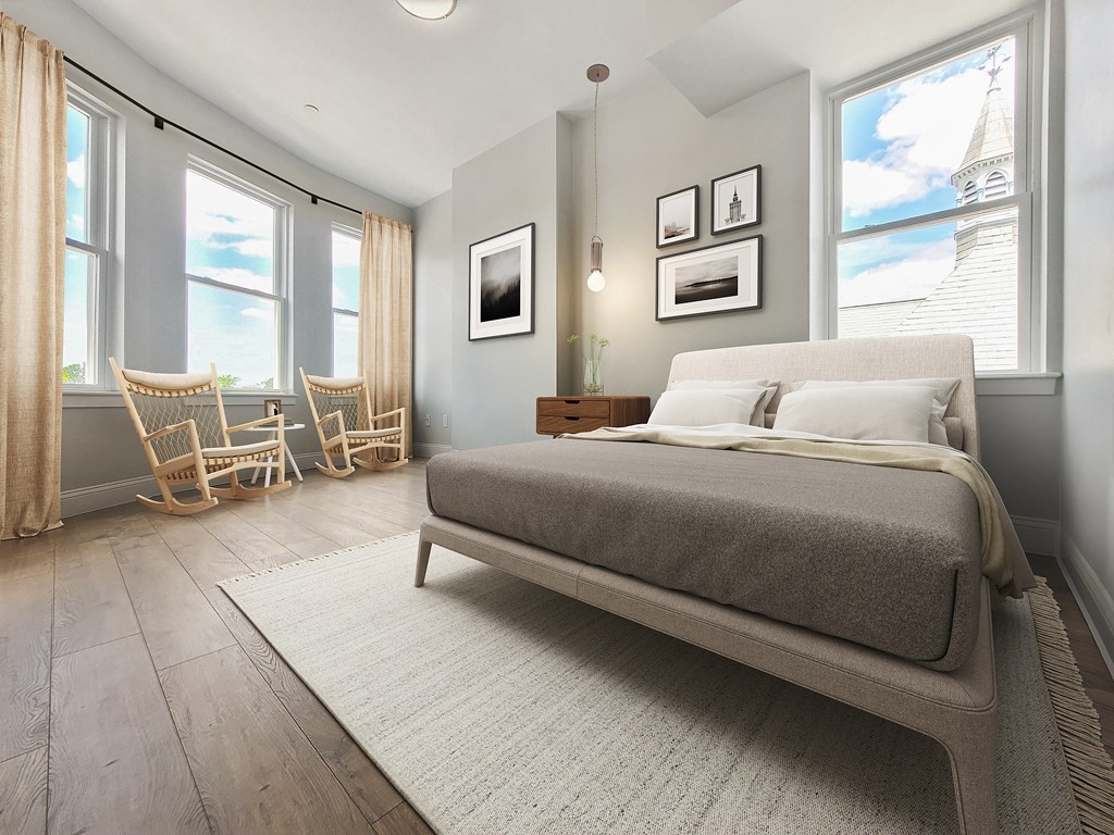 334-336 Warren Street, Unit 4 Boston, MA 02119 - Photo 3 of 10 a bedroom with a bed a table and chair with wooden floor