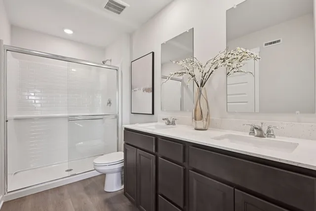 a bathroom with a double vanity sink mirror and toilet