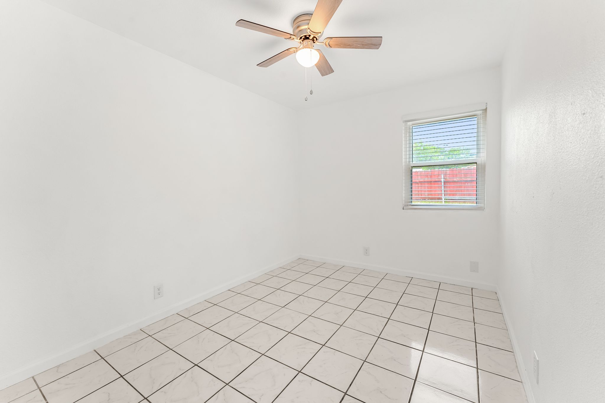 2501 Teri Road, Unit B Austin, TX 78744 - Photo 11 of 21 Room featuring square tile flooring, a window with horizontal blinds, and a ceiling fan with integrated lighting