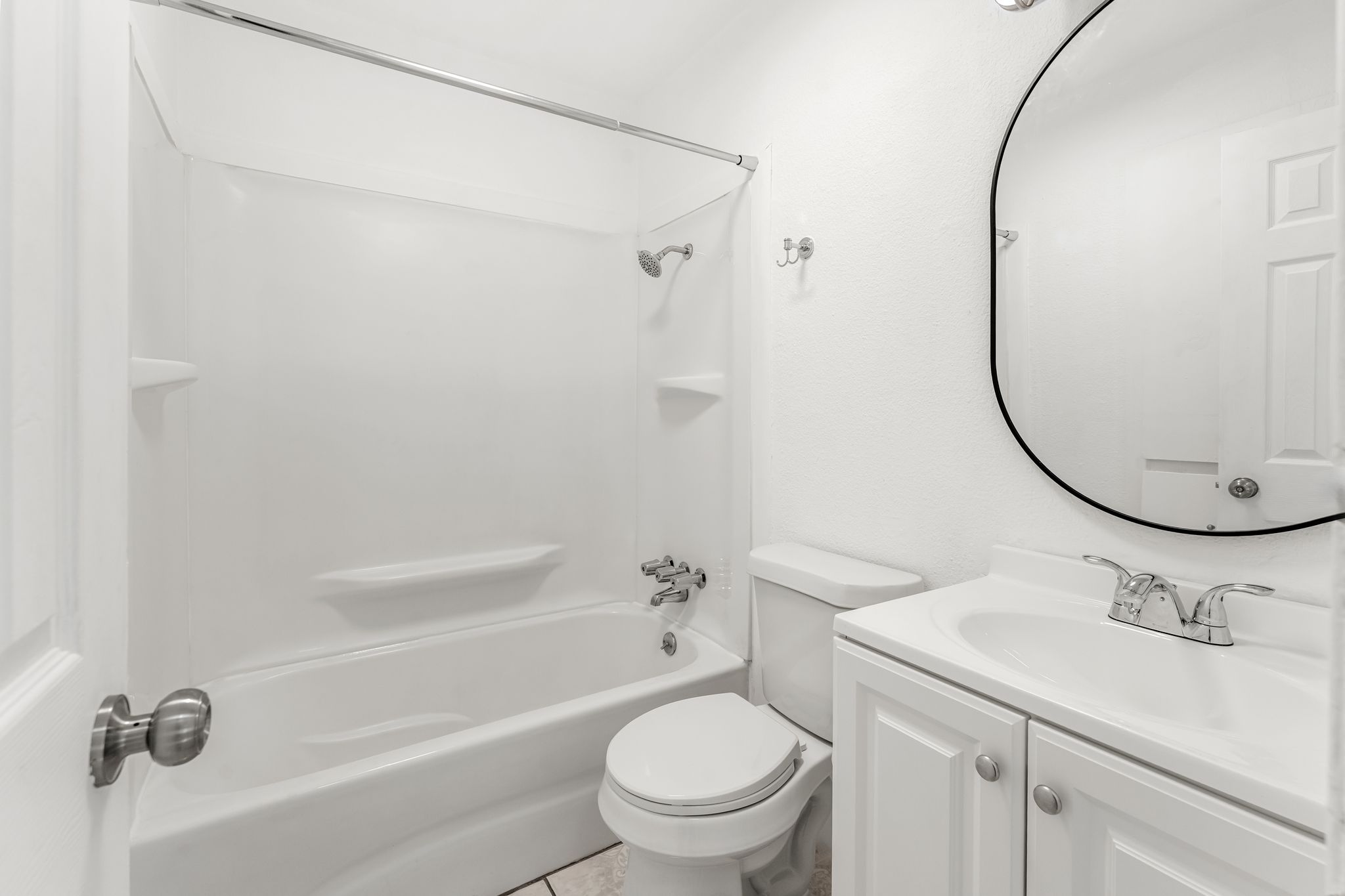 2501 Teri Road, Unit B Austin, TX 78744 - Photo 12 of 21 Bathroom featuring a white bathtub, a full shower surround, a vanity with a white basin sink, polished chrome fixtures, and an oval wall mirror