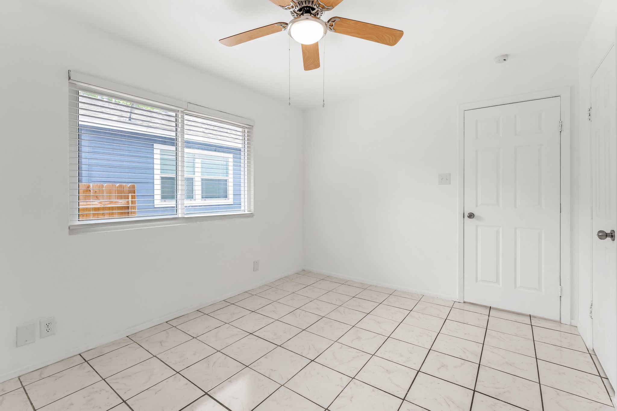 2501 Teri Road, Unit B Austin, TX 78744 - Photo 16 of 21 Bright room featuring a ceiling fan with light, tiled flooring, and a window with horizontal blinds