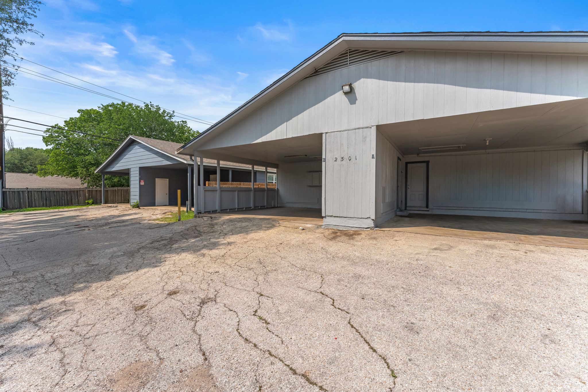 2501 Teri Road, Unit B Austin, TX 78744 - Photo 18 of 21 Two structures with gray siding and covered parking areas