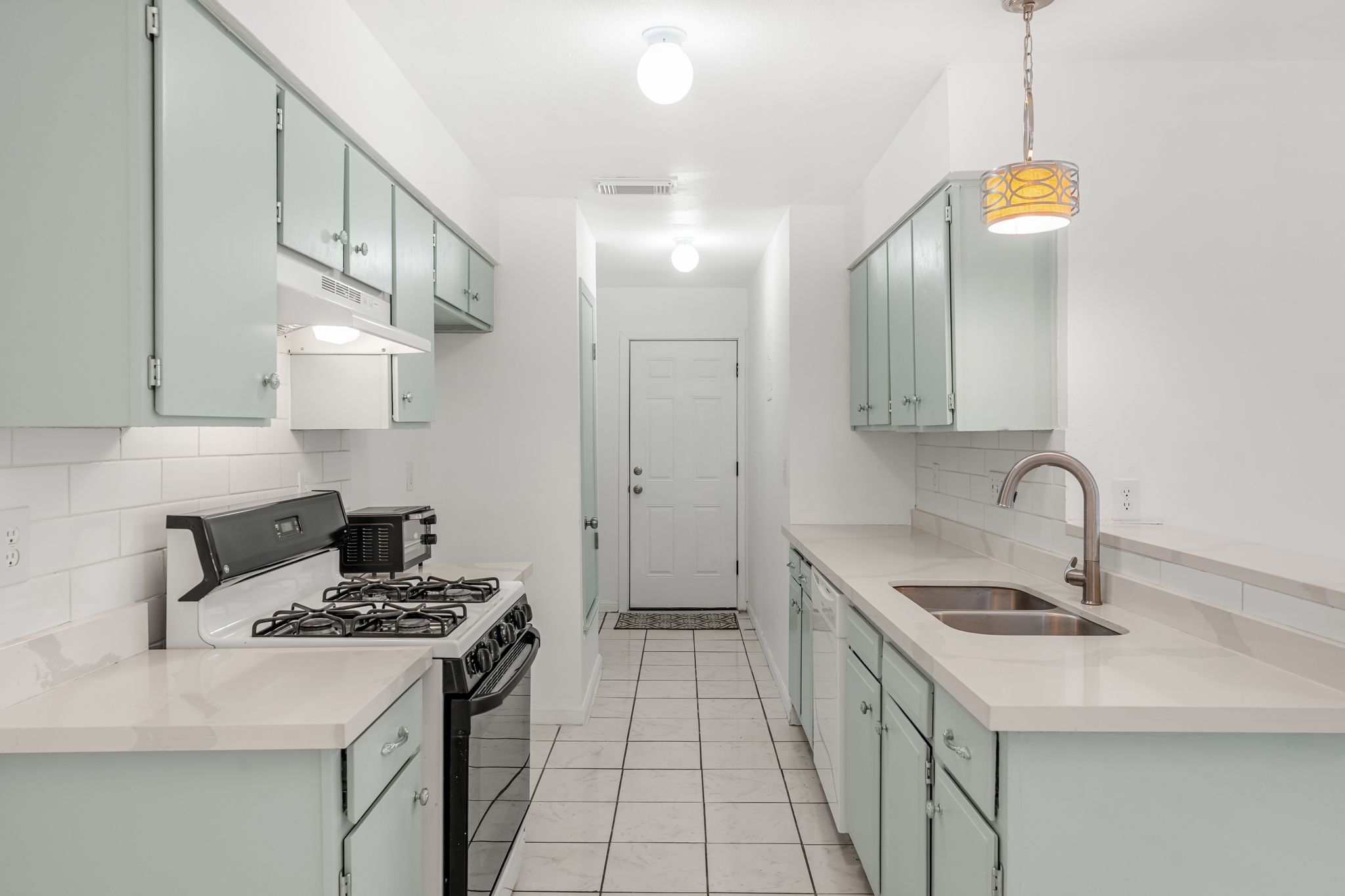 2501 Teri Road, Unit B Austin, TX 78744 - Photo 3 of 21 Galley kitchen featuring light-colored cabinetry, white subway tile backsplash, and light countertops